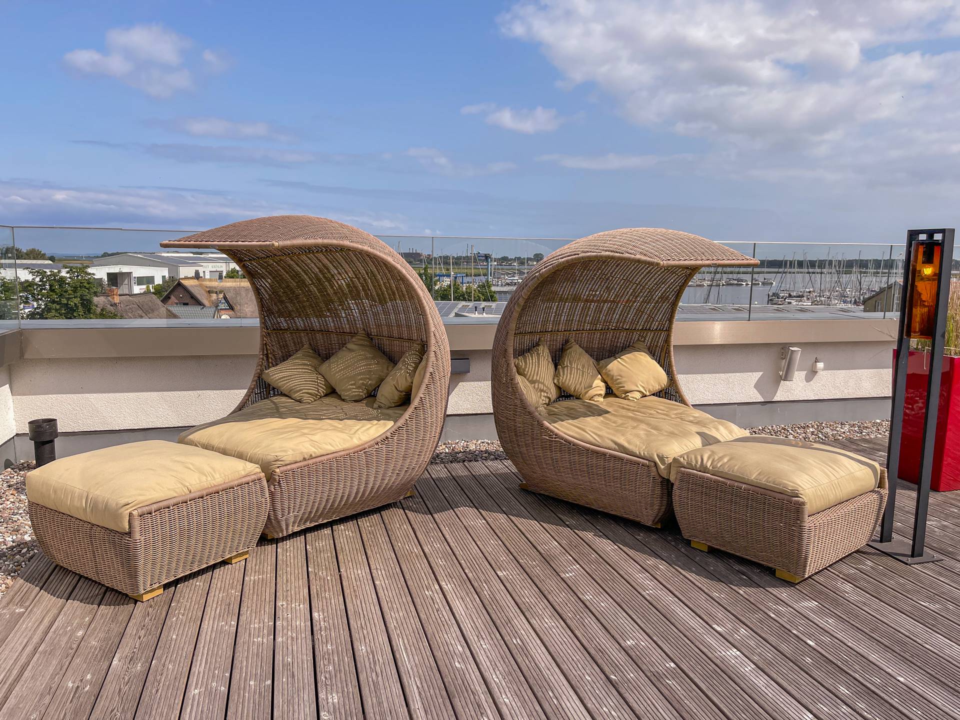 Sonnenterrasse mit Sonnenliegen mit Blick auf den Yachthafen