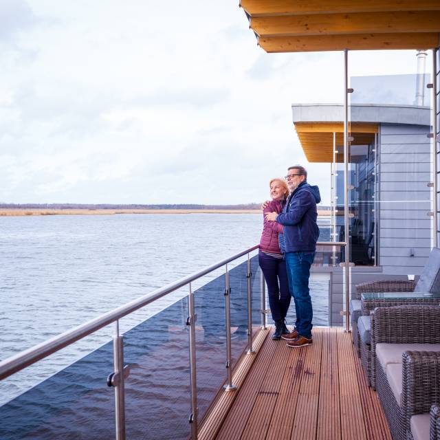 Mann und Frau auf Terrasse der schwimmenden Häuser in Kröslin