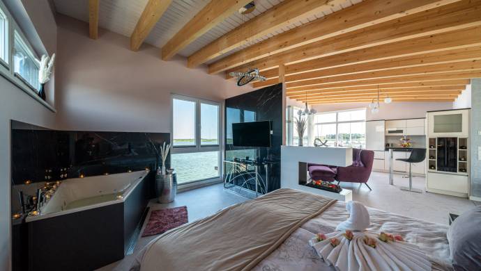 Innenansicht Suite des Floating House mit Badewanne und Doppelbett