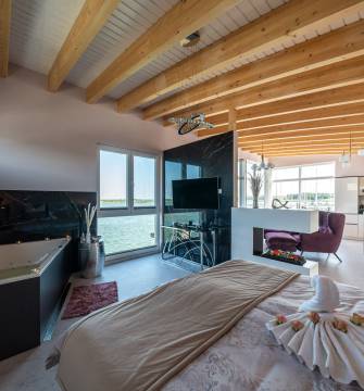 Innenansicht Suite des Floating House mit Badewanne und Doppelbett