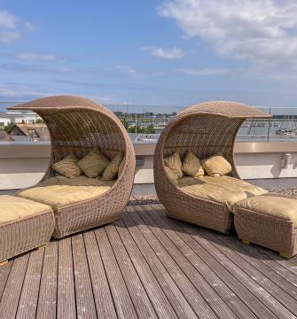Sonnenterrasse mit Sonnenliegen mit Blick auf den Yachthafen