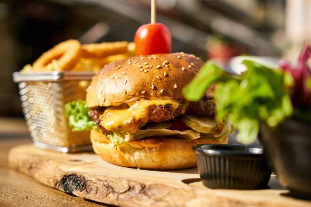 Cheeseburger mit Pommes auf einem Holzbrett