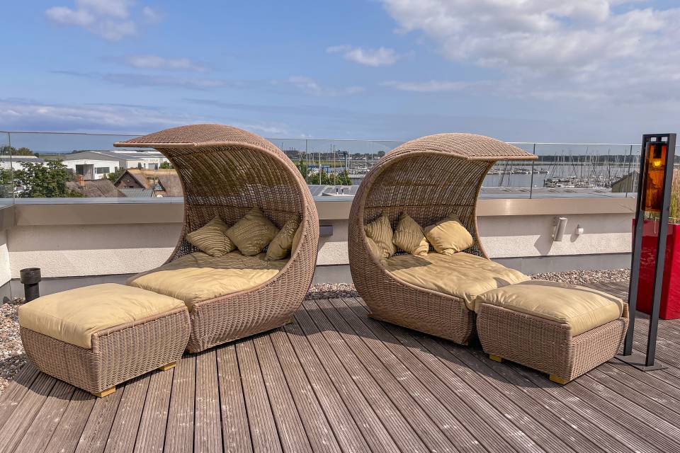 Sonnenterrasse mit Sonnenliegen mit Blick auf den Yachthafen