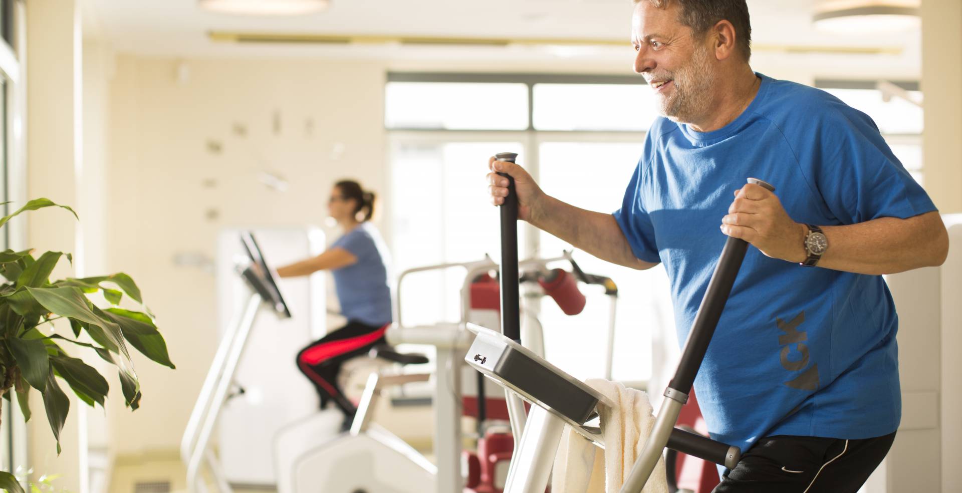 Mann auf Crosstrainer im Fitnessstudio des Baltic Sea Resort