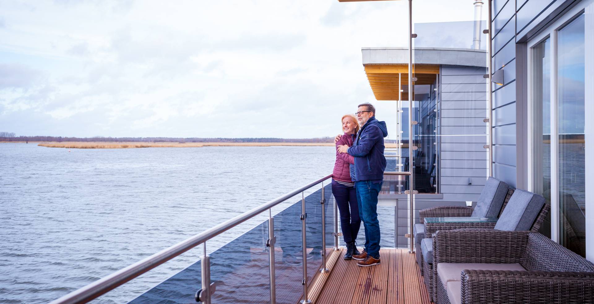 Mann und Frau auf Terrasse der schwimmenden Häuser in Kröslin