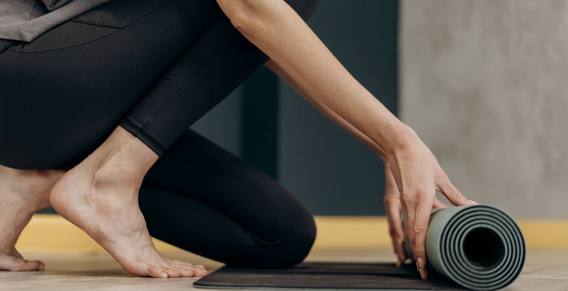 Frau rollt eine Yogamatte aus